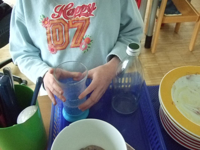 Diverses Geschirr, Kinderhände umfassen ein Glas